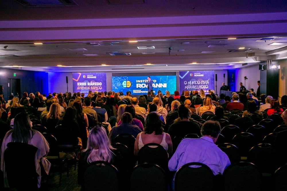 Participantes de pe durante uma dinamica do evento